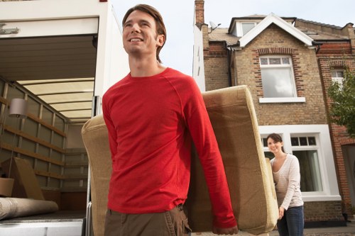 Professional movers carrying furniture from a flat in Wimbledon